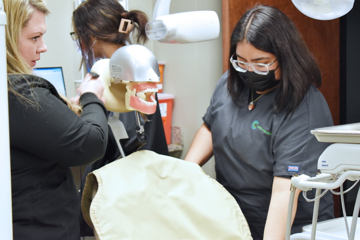 Dental Assisting student placing xray vest on chair