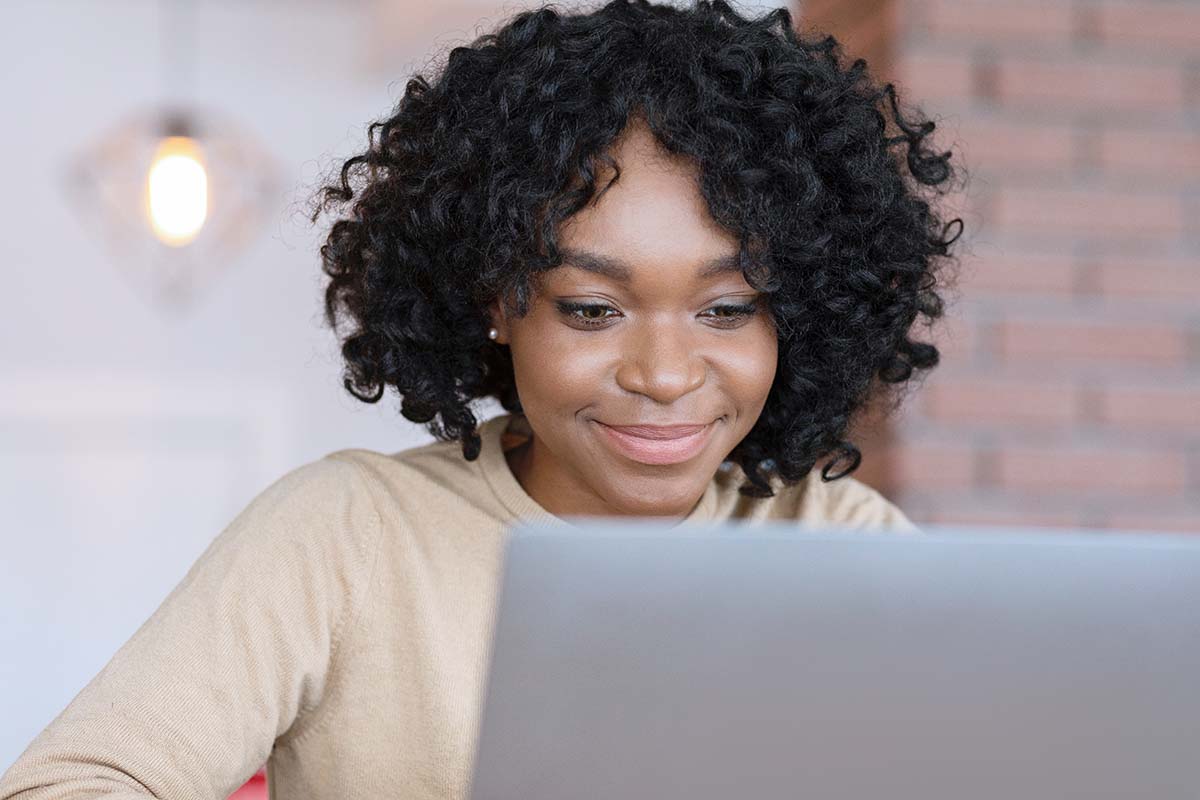 Young African American woman using laptop to apply online