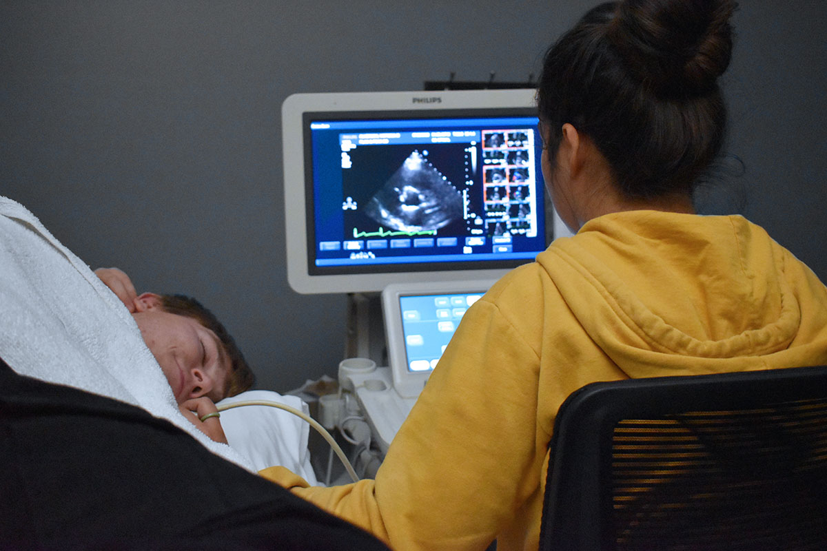 Caris College Cardiac Sonography student performing exam on fellow student