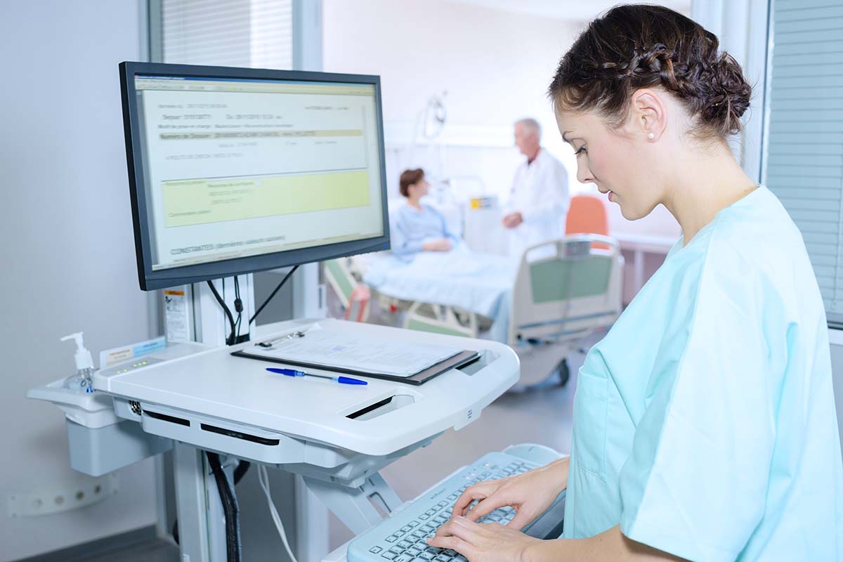 Practical nurse entering information into patient's electronic health record
