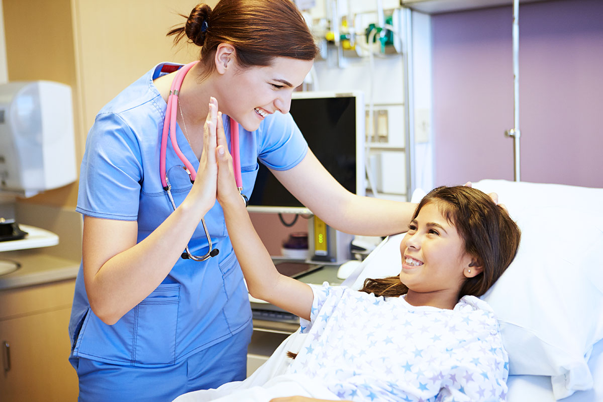 Practical nurse giving young patient a high five